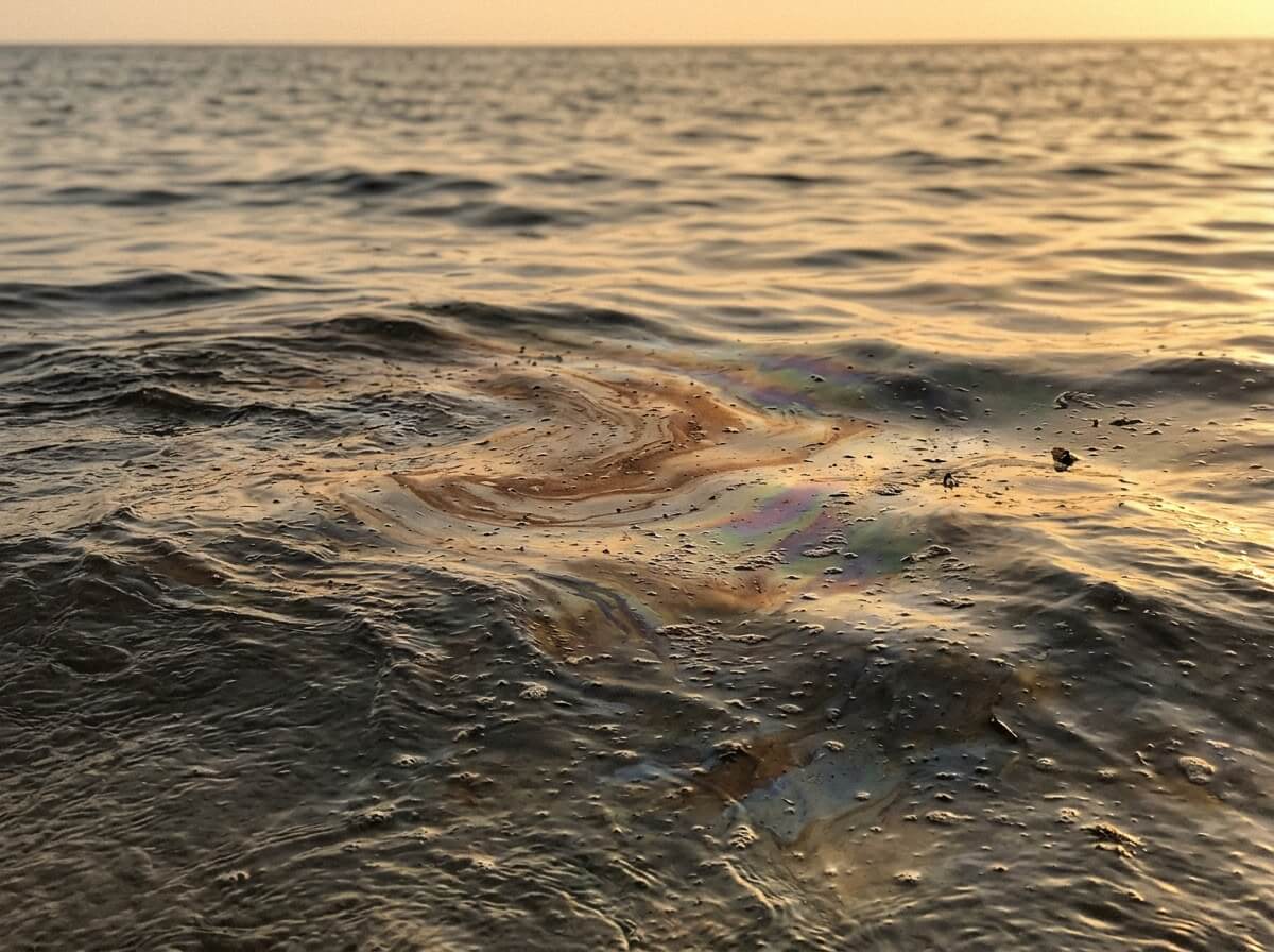 An oil slick on the sea surface at golden hour